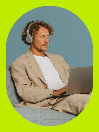 A man using a laptop with headphones, representing remote recruiting work.